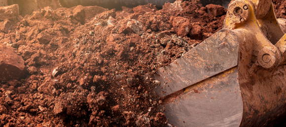 Dirt being dug up by excavator 