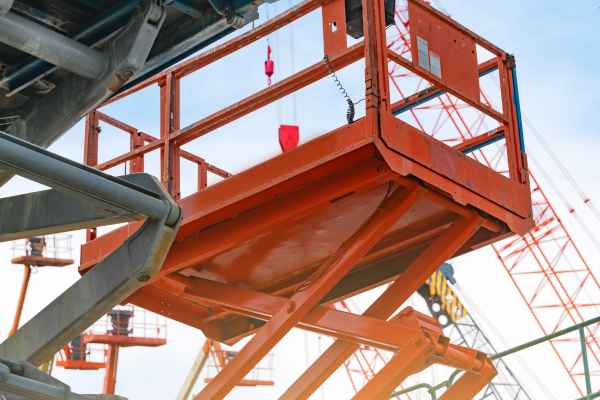 An orange boom lift at sunset